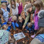 Kinder bei einer Bildungsveranstaltung der Biosphären-Ranger im herbstlichen Wald