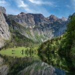 A steep rock face is reflected in the Obersee