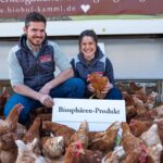 Familie Kamml mit ihren Hühnern vor dem Stall