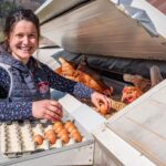 Steffi Kamml vom Biohof Kamml sammelt Biosphären-Eier im mobilen Hühnerstall