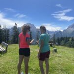 Passanten nutzen vor der Bergkulisse des Watzmann die App der Biosphären-Drehscheibe Ramsau