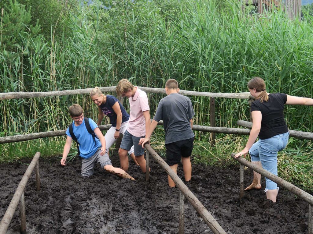 Schüler stapfen auf einer Exkursion durch den Matsch des Ainringer Moores