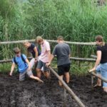 Schüler stapfen auf einer Exkursion durch den Matsch des Ainringer Moores