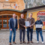 Übergabe der Partner-Urkunde vor dem Partnerbetrieb Enzianbrennerei Grassl