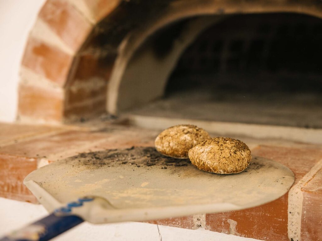 Semmeln werden aus einem Brotofen genommen