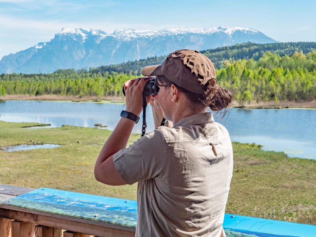 Biosphären-Rangerin beobachtet Vögel im Moor
