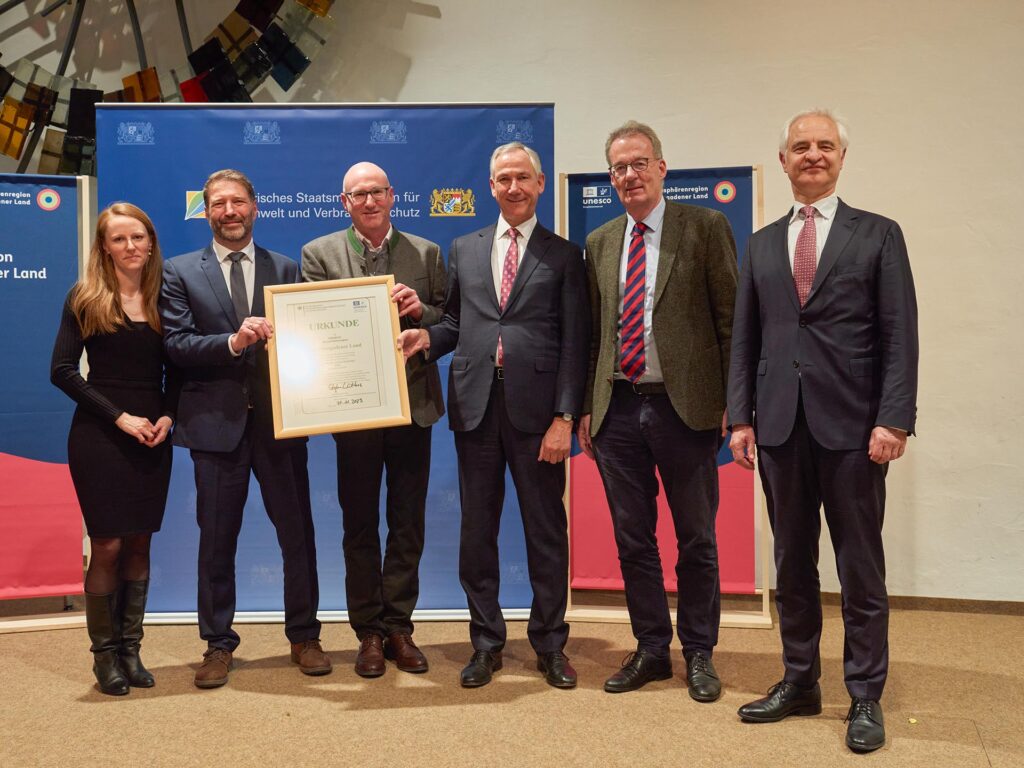 Gruppenfoto nach der Urkunden-Übergabe mit Bernadette Kneis (Stellvertretende Leiterin der Biosphären-Verwaltung), Dr. Peter Loreth (Leiter der Biosphären-Verwaltung), Bernhard Kern (Landrat Berchtesgadener Land), Dr. Christian Barth (Amtschef des Bayerischen Staatsministeriums für Umwelt und Verbraucherschutz), Dr. Stefan Lütkes (Vorsitzender des MAB-Nationalkomitees), Dr. Konrad Schober (Regierungspräsident von Oberbayern)