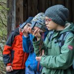 Kinder bestimmen beim Ferienprogramm "Entdeckertage" mit einem Kompass die Himmelsrichtungen
