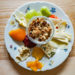 Biosphären-Frühstück: Teller mit Müsli, Obst und Käse