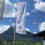 Fahne mit Schriftzug "Wir sind Biosphäre!" vor Bergkulisse