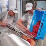 Die Metzgermeister Sichert und Braunsperger bereiten am Cutter die Fleischmasse der Biosphären-Kabanossi vor